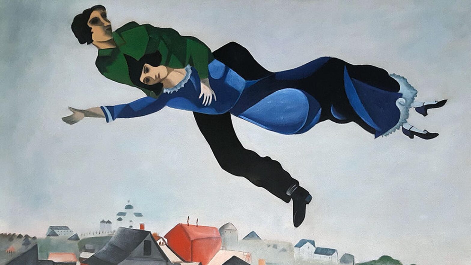 Reprodukcja obrazu Nad miastem autorstwa Marka Chagalla. Dwie postacie unoszą się w powietrzu nad miasteczkiem. Mężczyzna obejmuje kobietę, a ich ciała są lekko pochylone w locie. Ubrania w odcieniach zieleni i niebieskiego. Pod nimi widoczne dachy domów w spokojnych, przygaszonych kolorach. Całość ma miękki, trochę senny i poetycki nastrój.